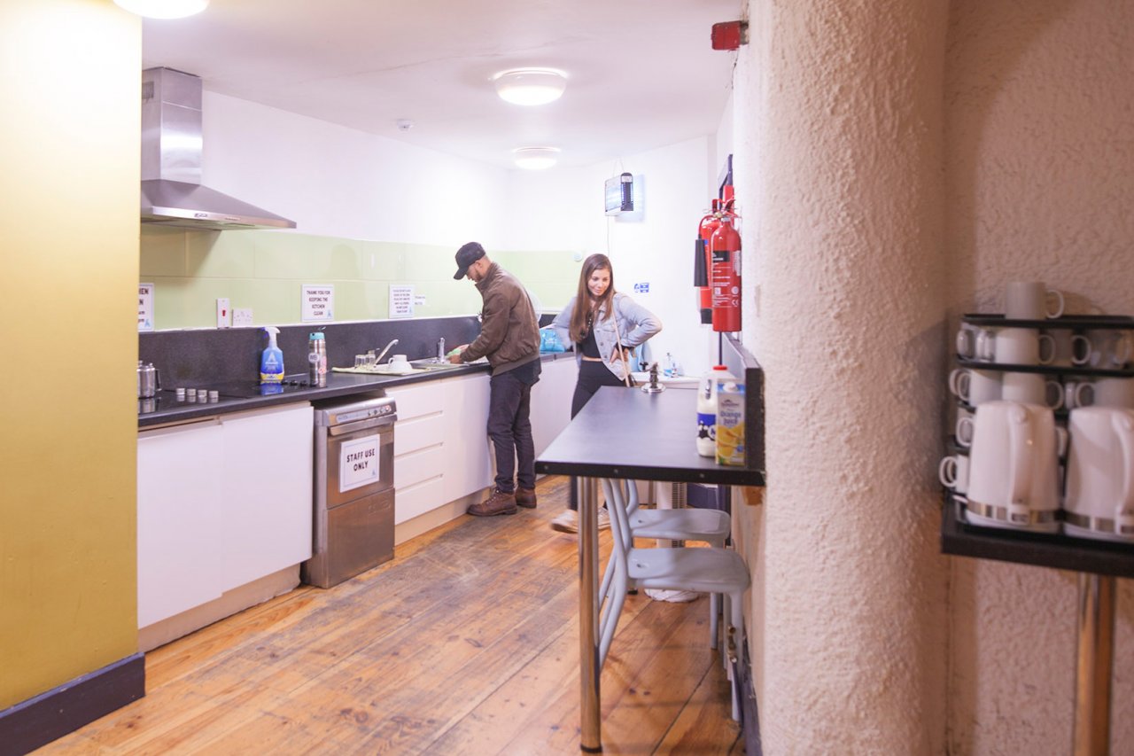 Tourists Preparing Food in the Self-Catering Kitchen in Hostel 
