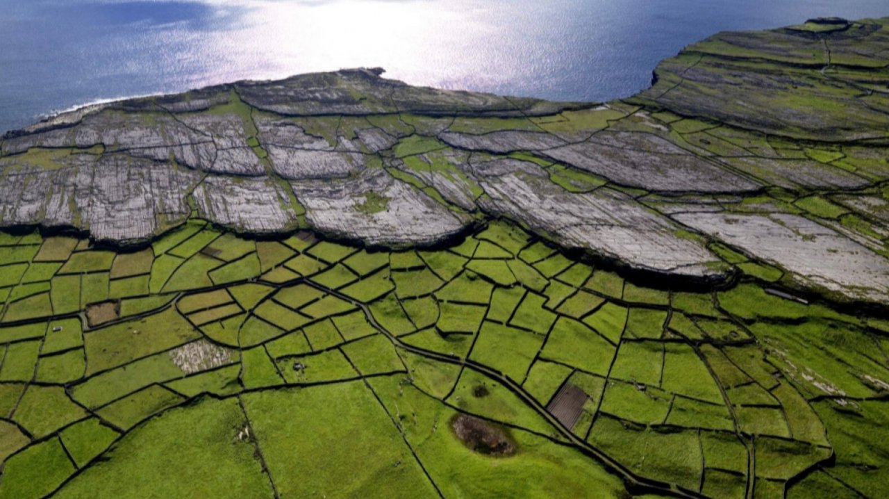 Ancient fields by the rocky coast - birds eye view of the green pastures and grey rocky landscape