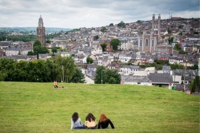 Students resting in a park watching the panoramic view of Cork city
