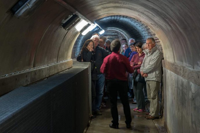Group of Visitors in Underground Tunnels