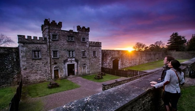 A couple watching the sun go down behind Cork City Gaol