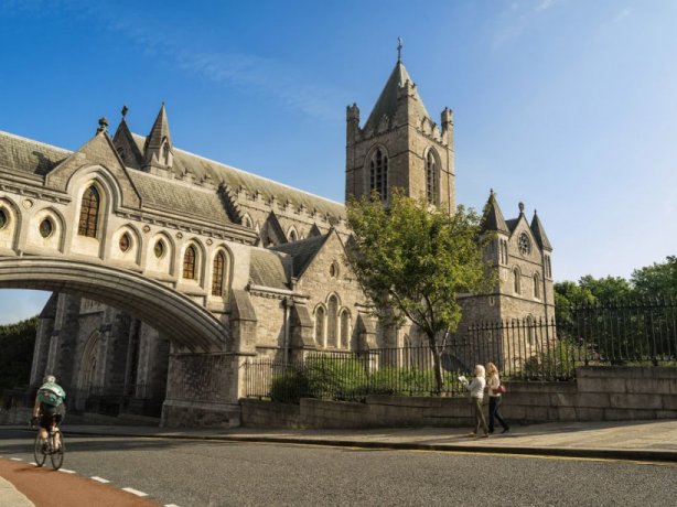 People walking and riding towards Christ Church Cathedral bridge