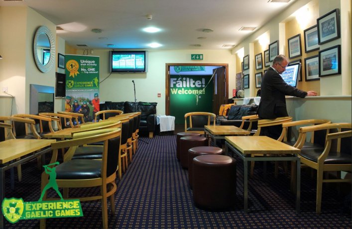 Tables, Ottomans and Chairs in a n arranged club house function room with big TV screens and club's memorabilia