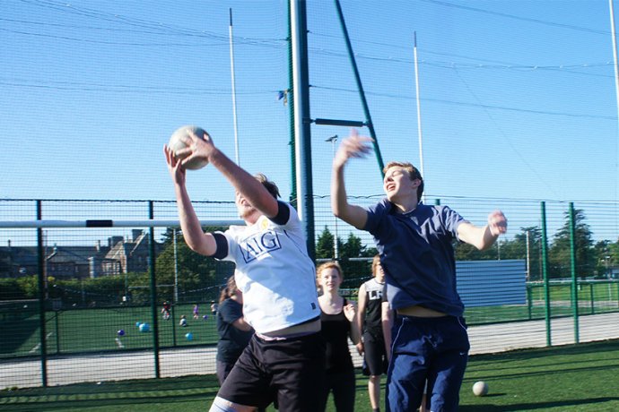 Group Playing Actively Gaelic Football Outside in Dublin