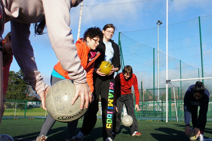 Group Practising Gaelic Football on Field in Dublin