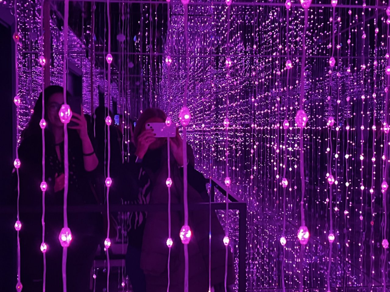 Visitors form School Group Photograph Themselves in the Mirror reflections of the Infinity Room with Lights set to Deep Purple