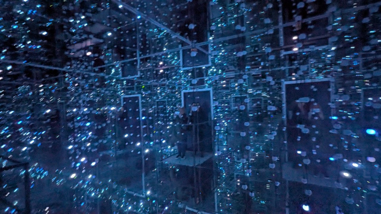 Room Arranged to show the Infinity effect using lights and mirrors in a small space . Blue lights on strings of cables interestingly shaped  to  create effect