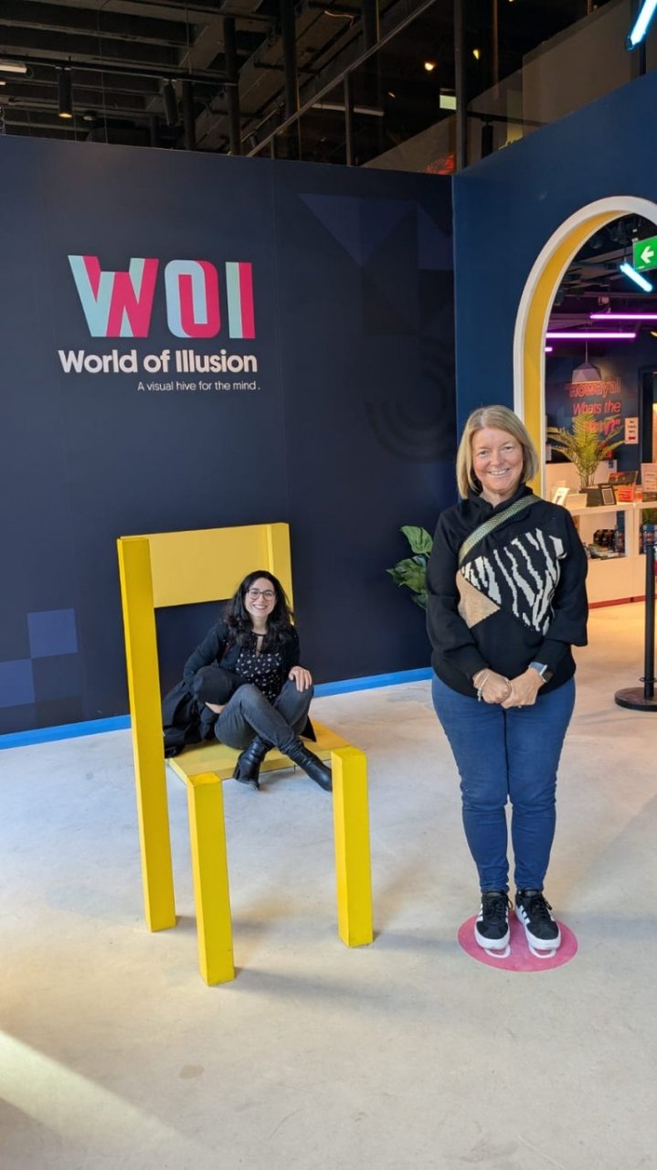 Perspective trick with visitors posing for the picture using fake chair to emphasise the size difference