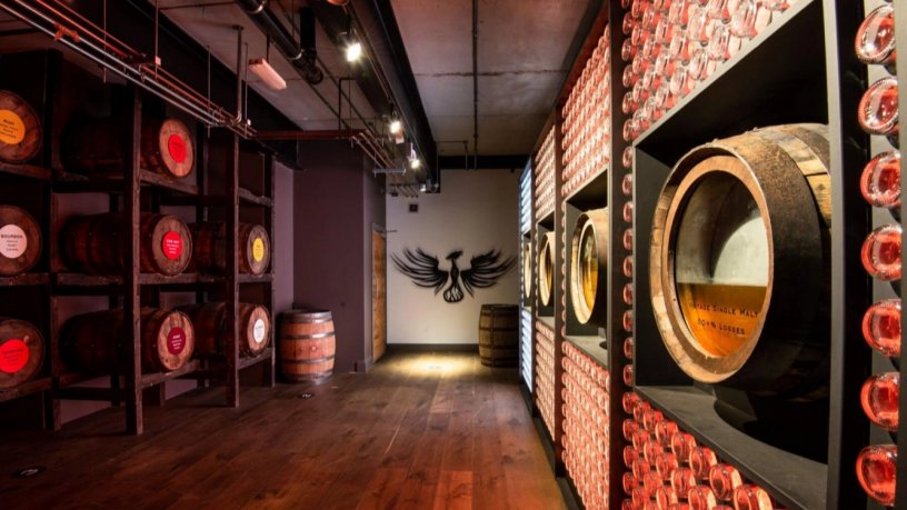 Arranged Exposition of Barrels in the Distillery Exhibition Room Teelings Logo on the wall