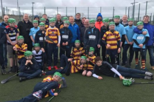 Gaelic games teams of students posing for a picture on Astroturf in a full kit