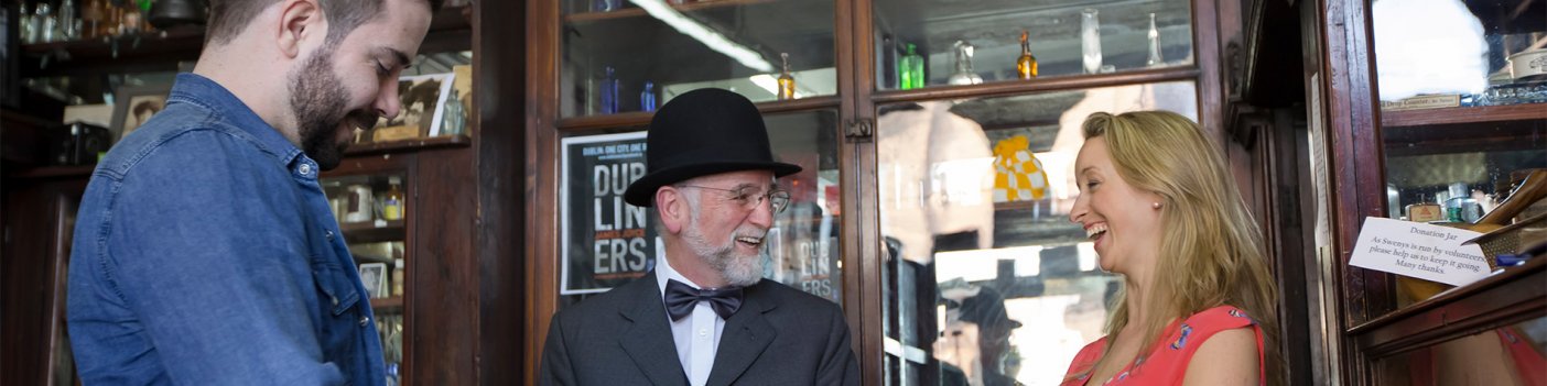 Tourists laugh in conversation with their tour guide outside Sweny's Pharmacy - a stop on Pat Liddy's James Joyce Ulysses Tour.