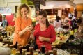 Two women choosing from a sellection of jams