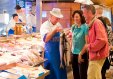 Market clerk showing off fresh fish