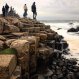 Group Of Students Standing on a Giant's Causeway Basalt Columns by the Atlantic Ocean