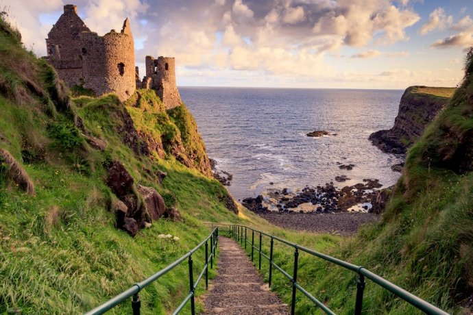 Dunluce Castle Steps Down To The Ocean's Rocky Beach