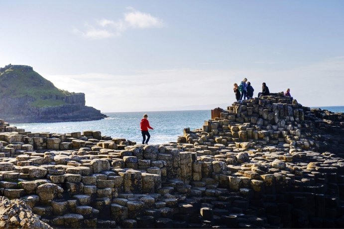Sunny Day on Giant's Causeway Group of Students On Basalt Columns