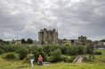 View of Trim Castle with a group of people walking away  from the castle grounds during overcast weather