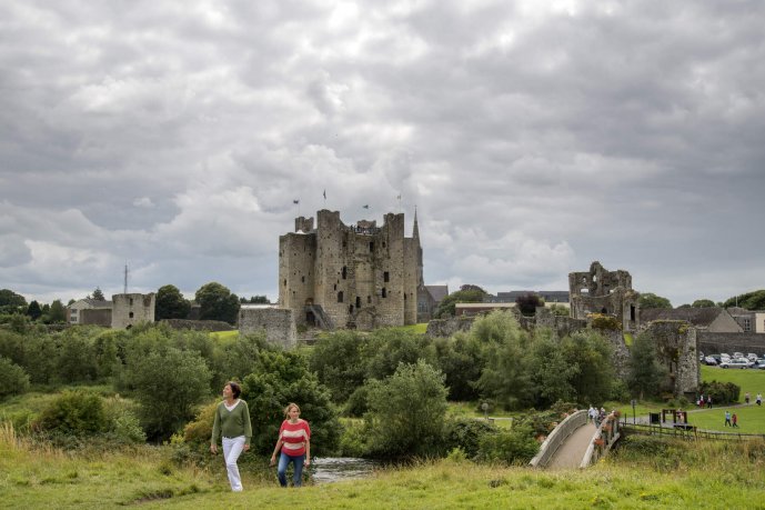 View of Trim Castle with a group of people walking away  from the castle grounds during overcast weather
