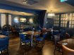 restaurant group seating with brow square tables, blue chairs, blue walls and brown floors. Affordable 2 or 3 course meals for groups in Dublin
