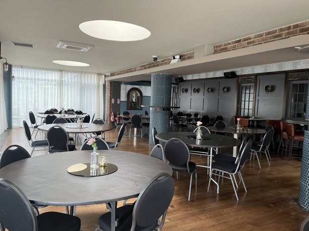 restaurant area with blue circular tables, blue chairs, blue walls and white ceiling.  Budget 2 or 3 course meals for groups