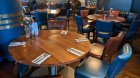 group eating area with round brown tables, brown and blue chairs, brown floor. Affordable restaurant for School group meals in Dublin city centre