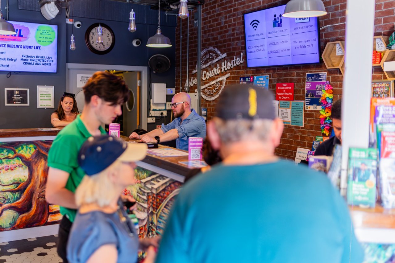 Reception Staff at work checking in and out groups of students at the Abbey Court Hostel in Dublin 