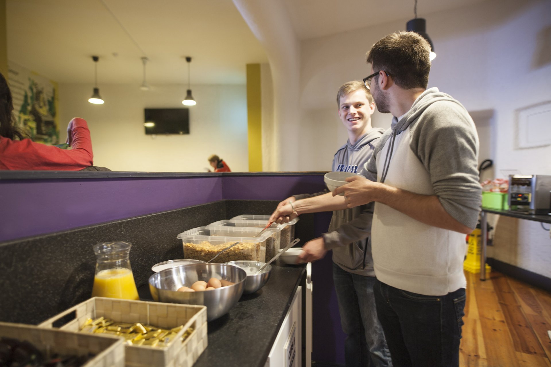 Tourist Residents Enjoying Continental Breakfast in Hostel