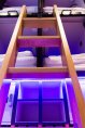 access ladder to upper capsules in pod hostel brightly lighted