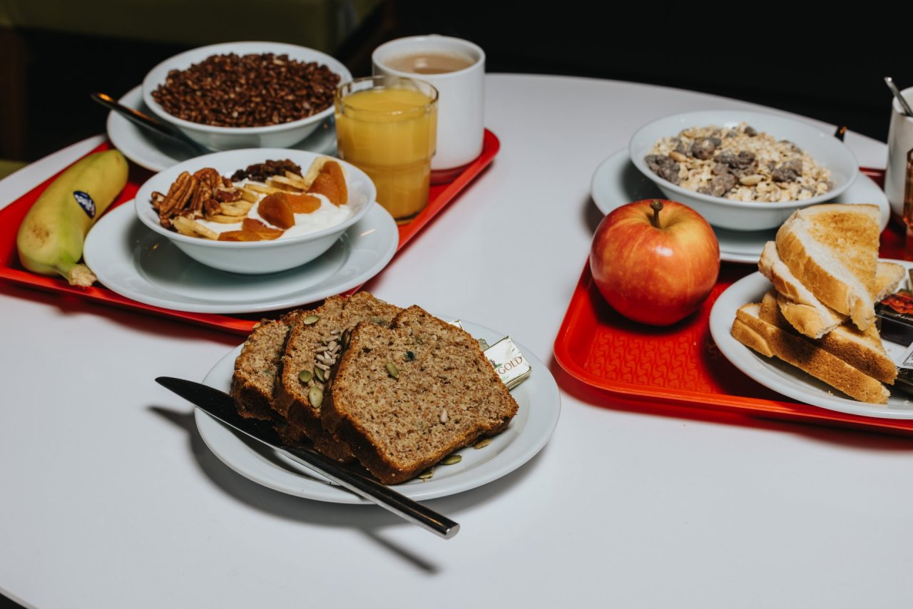 Red trays with toasts and continental breakfast for groups booked in the hostel