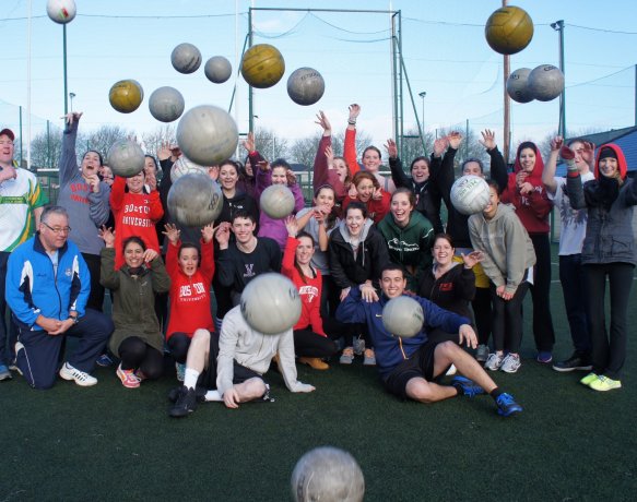 Students throwing GAA balls in the air at a Gaelic Football pitch in Ireland 