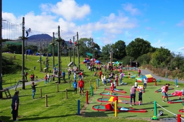 Group of students at busy adventure centre on a sunny day