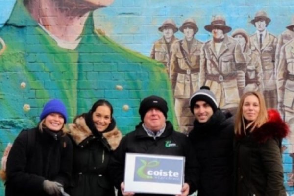 Belfast Historical Walking Tours Group of People with Coiste Tour Guide at the back Mural with Irish Political Theme