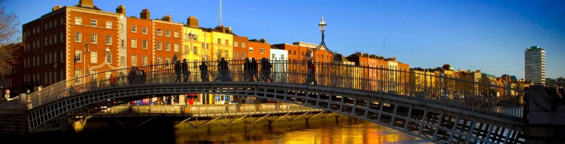 Group of people crossing the Ha'Penny Bridge on a sunny day in Dublin