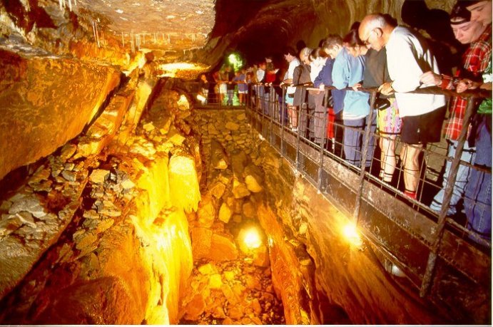 Visitors looking at a cascade underground in the Caves